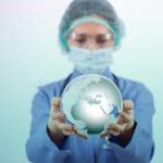 A doctor holding a globe in front of him.