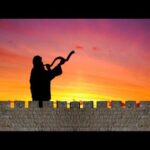A person playing the saxophone in front of a sunset.